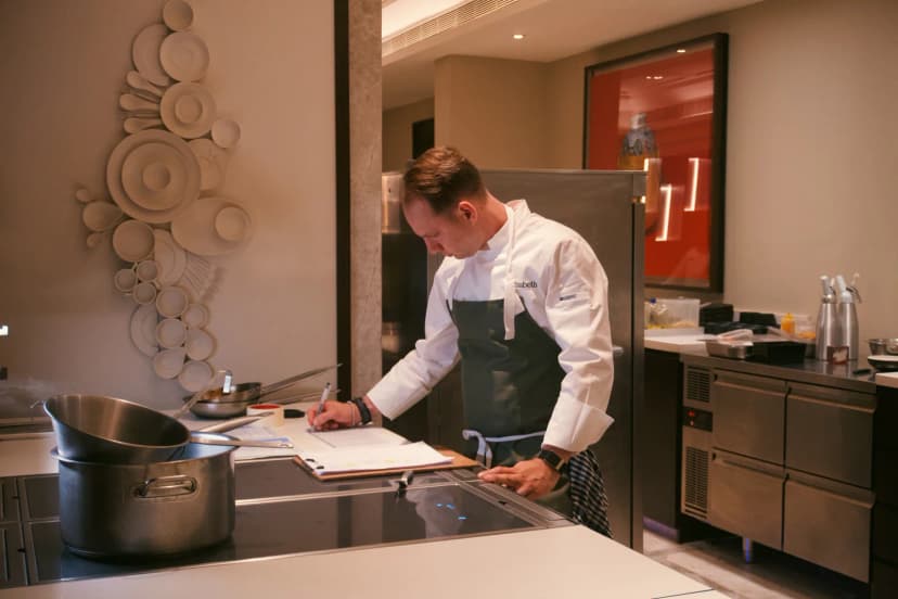 Jason reviewing handwritten notes at a kitchen counter in Hyderabad