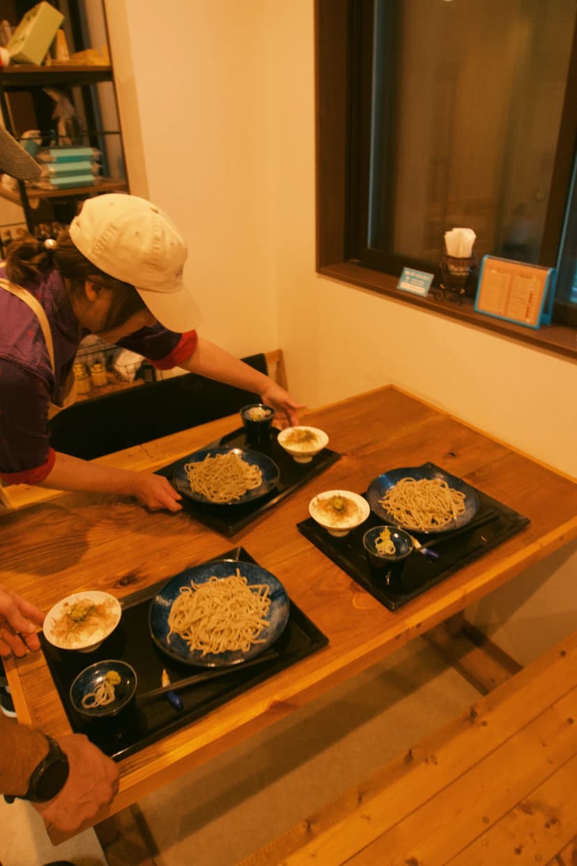 Diners seated at a wooden counter with plates of food in Yunotsu