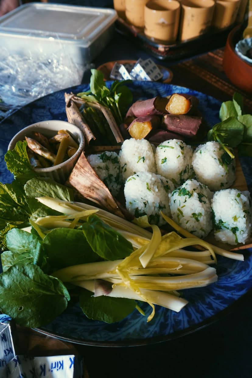 Rice balls and vegetables arranged on a blue plate in Japan