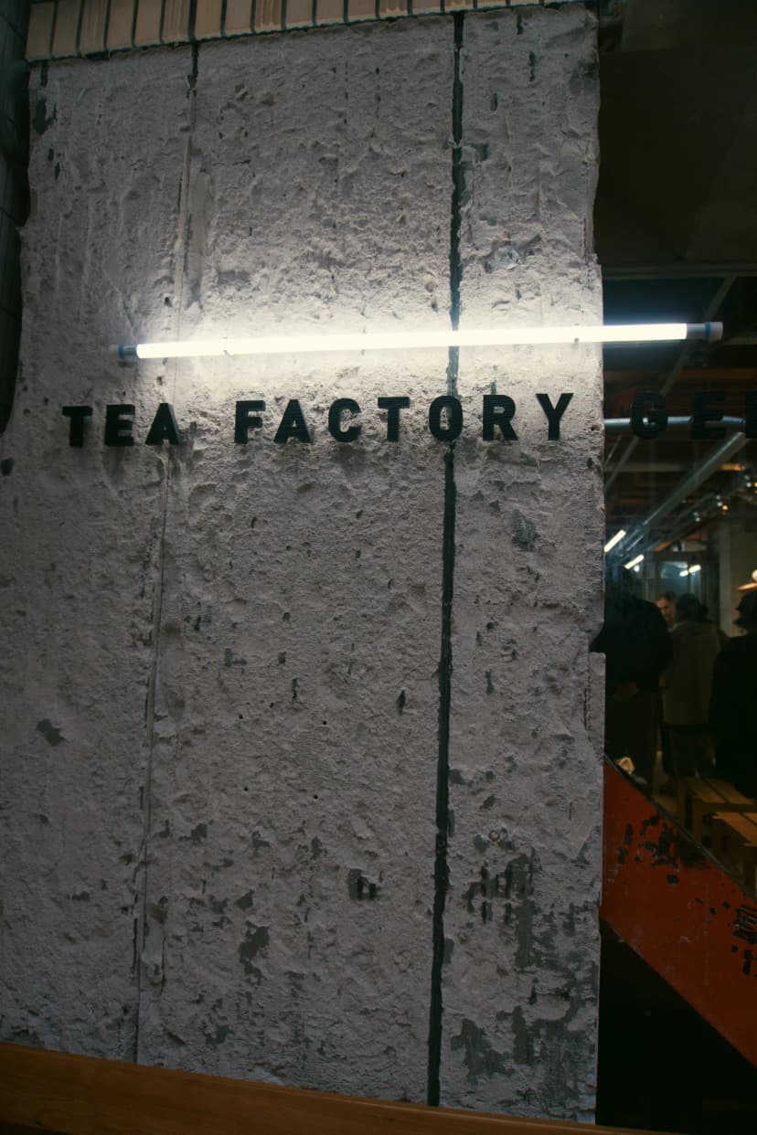 The words Tea Factory mounted on a concrete entrance wall