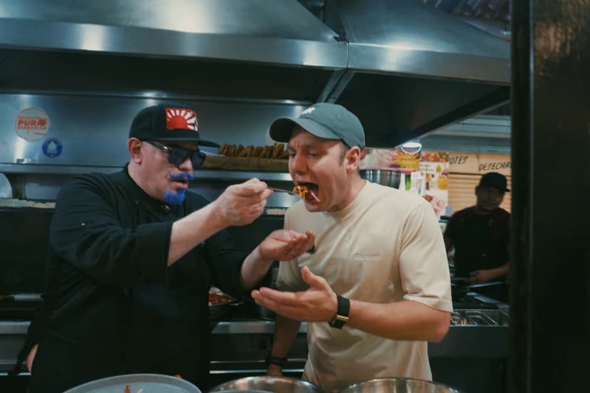 A chef offering Jason a bite of food at a Mexico City market counter