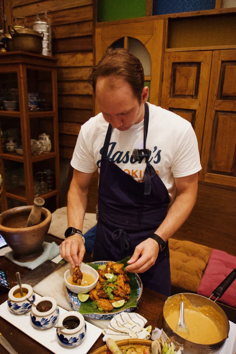 Jason finishing a dish during a cooking session in Thailand